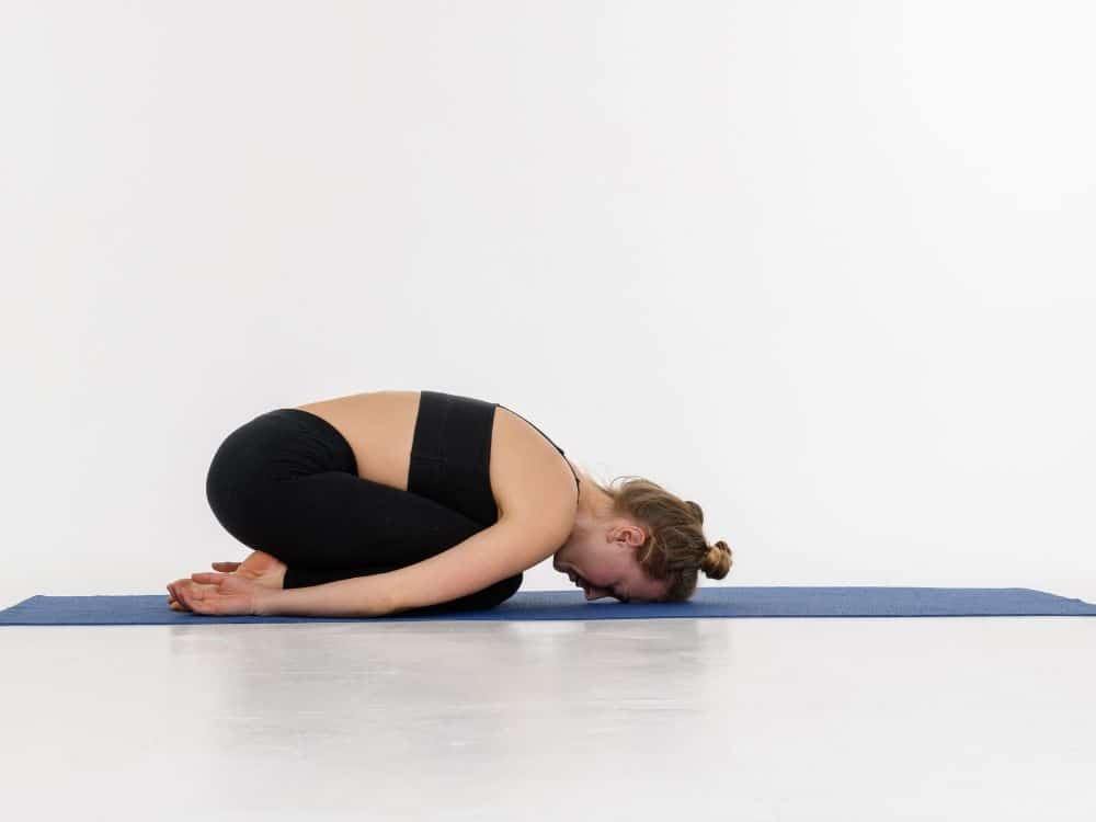 Os exercícios de alongamento são essenciais para manter a flexibilidade da coluna e prevenir lesões. a posição criança é uma das melhores opções.